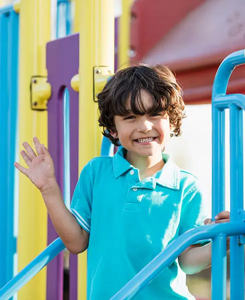 Contact Montessori Childcare, boy waving playing outside